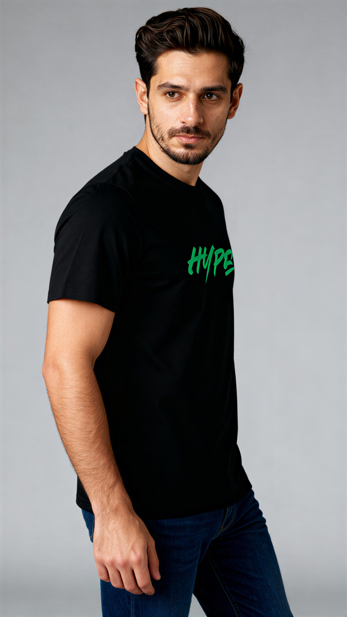 במבט צדדי, גבר לובש חולצת כותנה אורגנית שחורה עם הדפס ירוק בוהק של המילה "HYPE" מבית פיורלום.