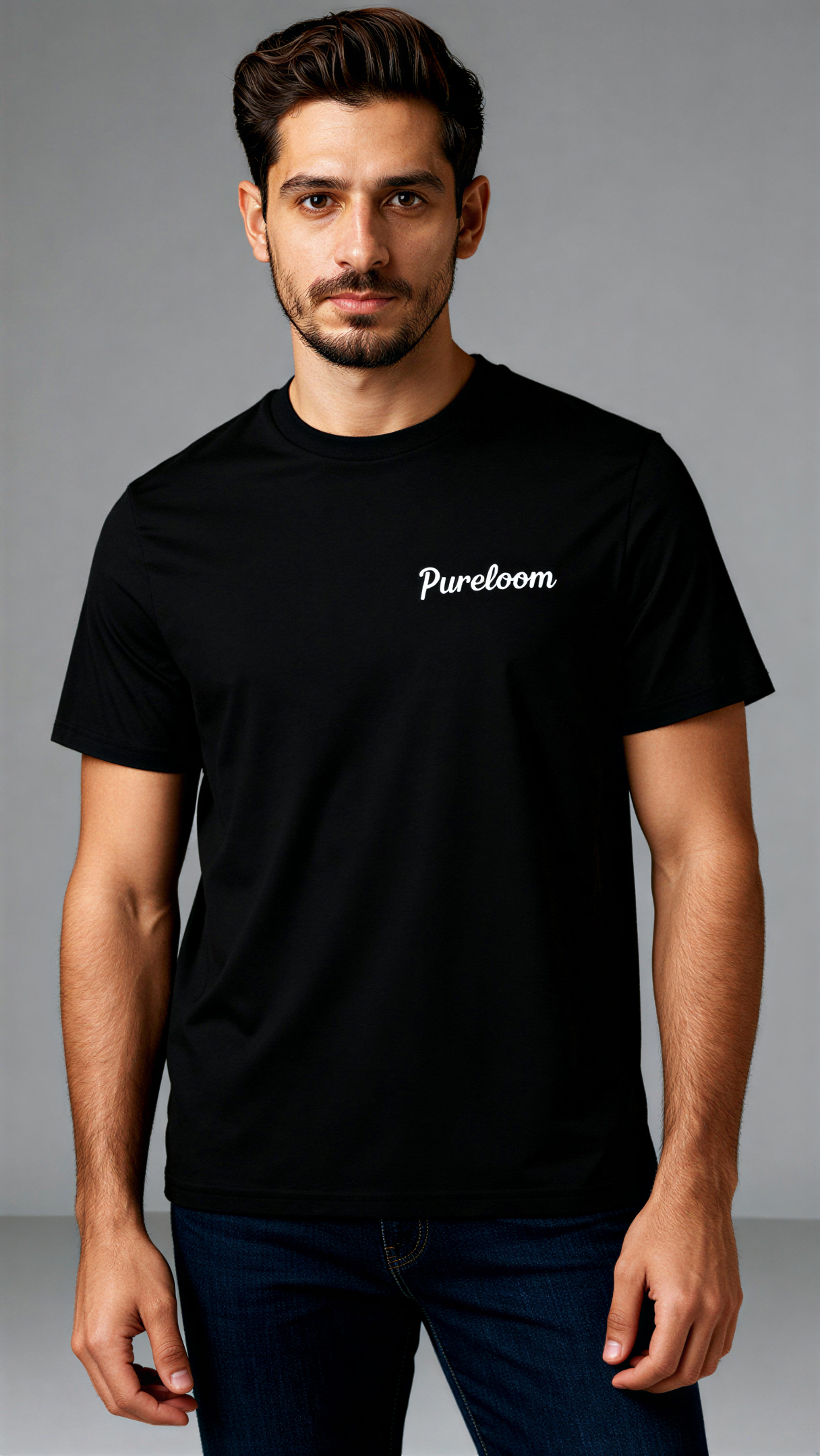 במבט קדמי, גבר לובש חולצת כותנה אורגנית שחורה עם לוגו לבן "Pureloom" בצד שמאל של החזה מבית פיורלום.