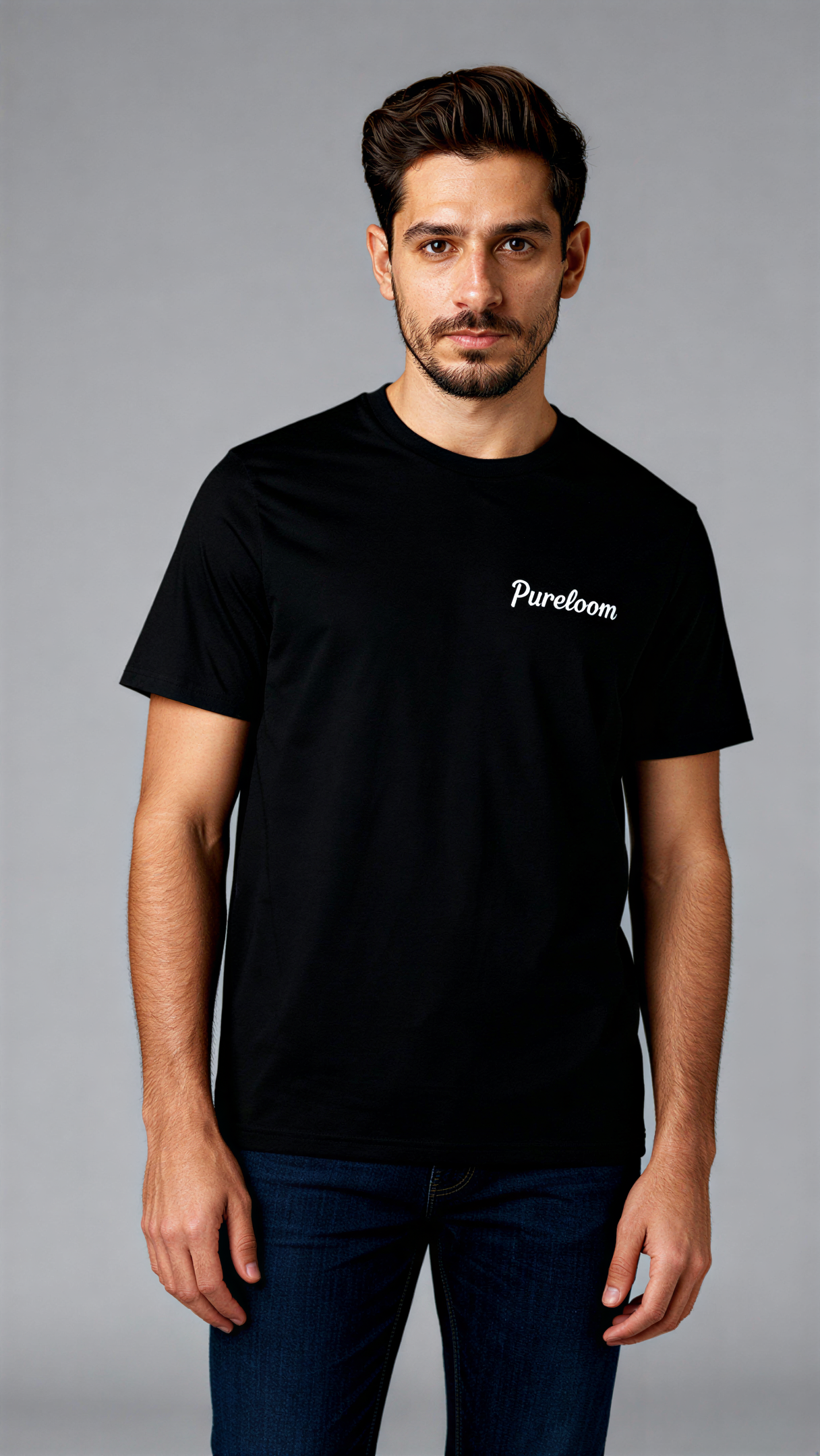 במבט קדמי, גבר לובש חולצת כותנה אורגנית שחורה עם לוגו לבן "Pureloom" בצד שמאל של החזה מבית פיורלום.